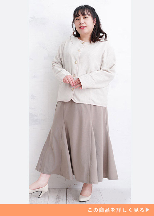 アイボリーのクラシックジャケットとマーメイドスカートのコーデに白いパンプスを履く女性