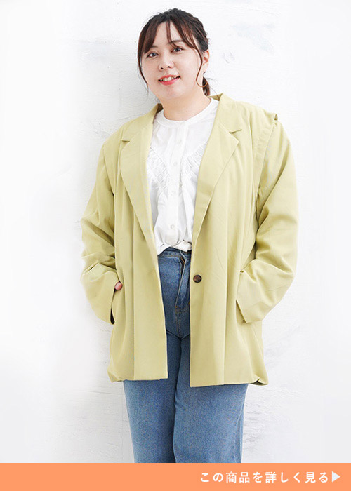 ライムイエローのジャケットとホワイトブラウスのコーデにデニムパンツを履く女性