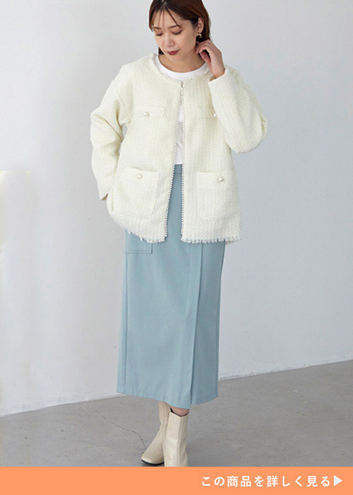 オフホワイトのツイードジャケットとアイスブルーのスカートのコーデに白いブーツを履く女性