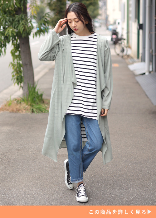 白T×黒パンツにブルーのカーデを羽織り、スニーカーを履く女性