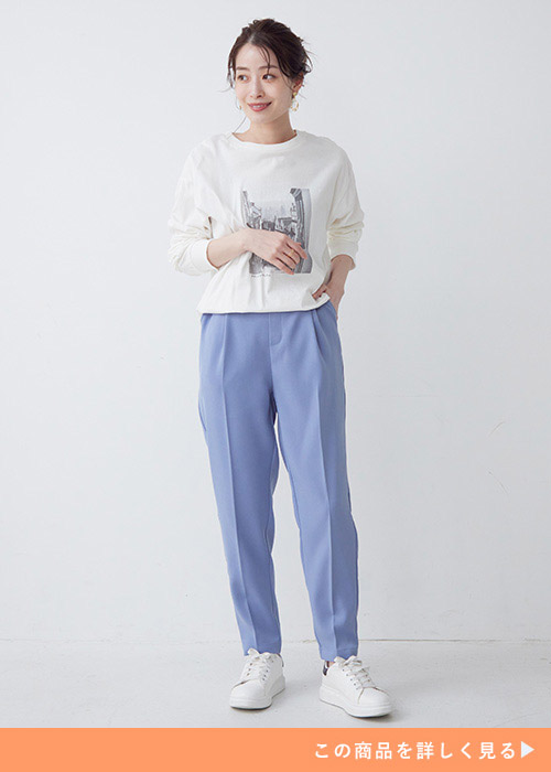 ロンT×サックスブルーのテーパードパンツにスニーカーを履く女性