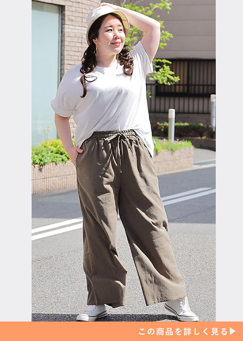 白T×カーキのワイドパンツに、白のハイカットスニーカーを履く女性