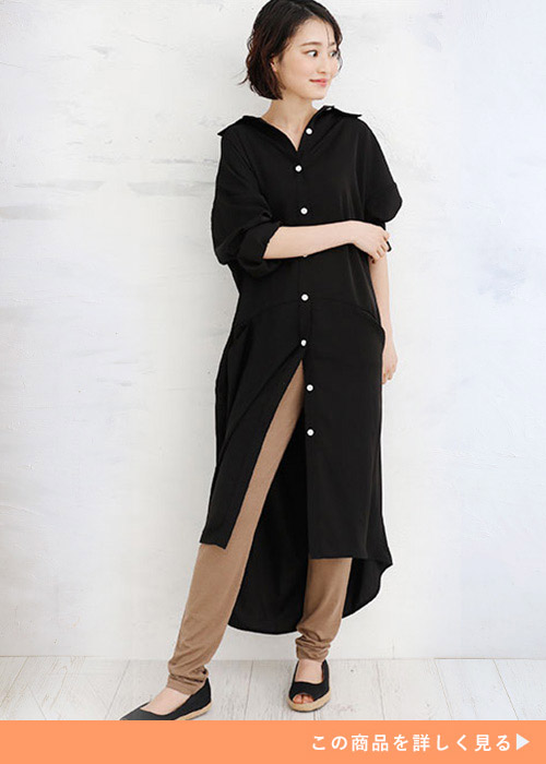 黒のシャツワンピースを着て、モカブラウン色のレギンスを履く女性