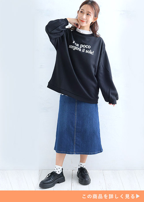 デニムのスカートと黒のトレーナーのコーデに黒スニーカーを履く女性