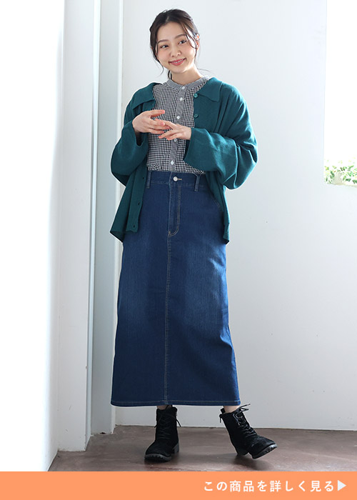 デニムタイトスカートとチェックのブラウスのコーデにグリーンのニットカーデを羽織る女性