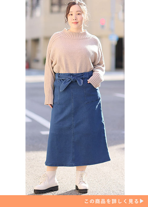 デニムタイトスカートとニットトップスのコーデにショートブーツを履く女性