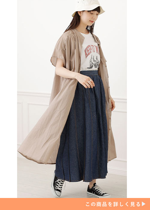 タック入りデニムロングスカートとTシャツのコーデに半袖ロングシャツを羽織る女性