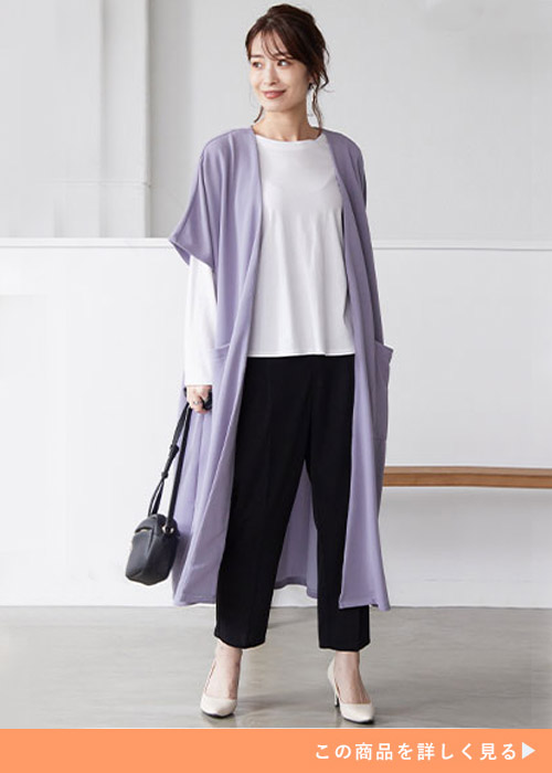 白トップス×黒パンツに、ラベンダーブルーの半袖ジレを羽織る女性