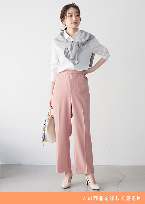 白シャツ×ピンク色パンツコーデにグレーのトップスを肩に巻く女性