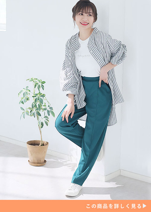 白T×グリーンのテーパードパンツに、ストライプ柄のオーバーサイズシャツを羽織る女性