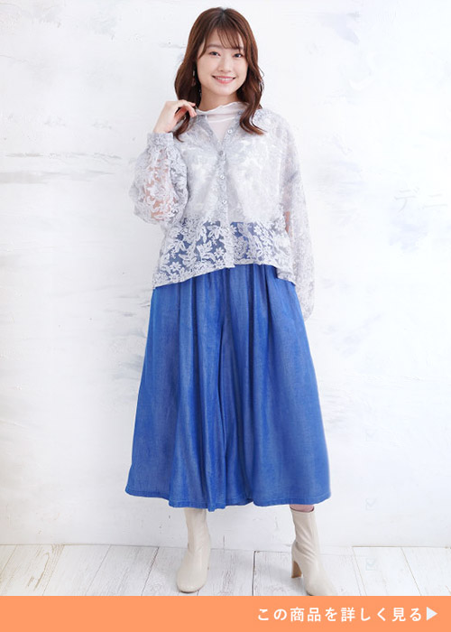 白のシースルートップス×デニム風ガウチョパンツに総レースカーディガンを羽織る女性