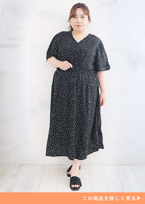 黒地に白のドット柄ワンピースを着る女性