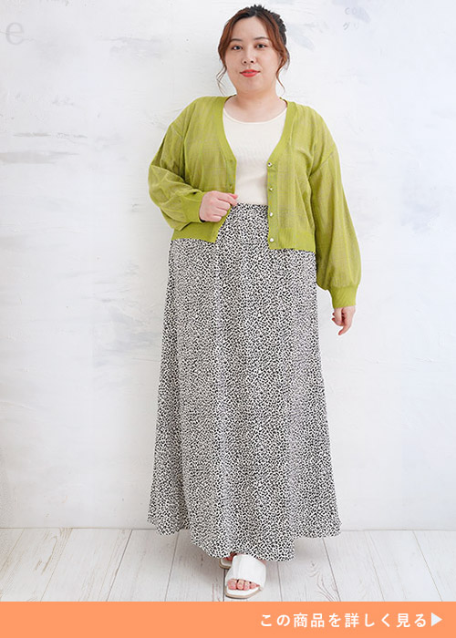 白トップス×レオパード柄マキシ丈スカートにグリーンのシアーカーディガンを羽織る女性