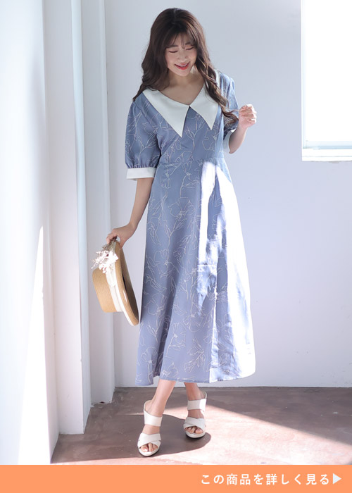 ブルーグレーのビッグカラープリントワンピースに合わせて白いサンダルを履く女性