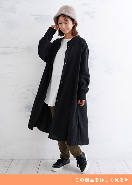 白いトップスとカーキズボンのコーデにブラックのフランネルシャツを羽織る女性