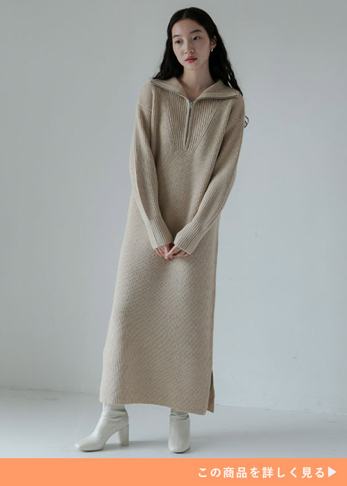 ベージュのニットロングワンピースに合わせて白いブーツを履く女性