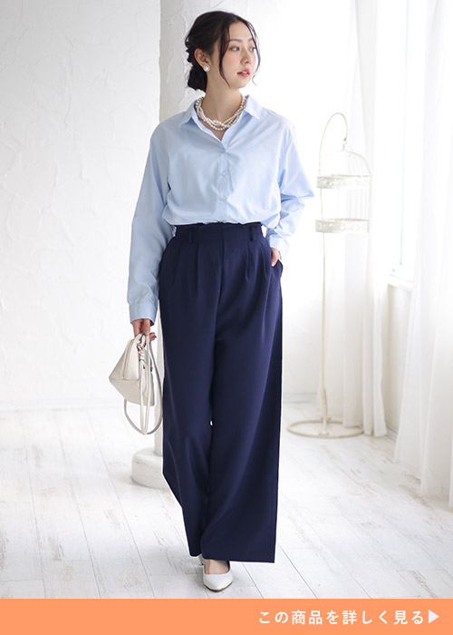 サックスブルーのシャツを着て、ネイビーのワイドパンツを履く女性