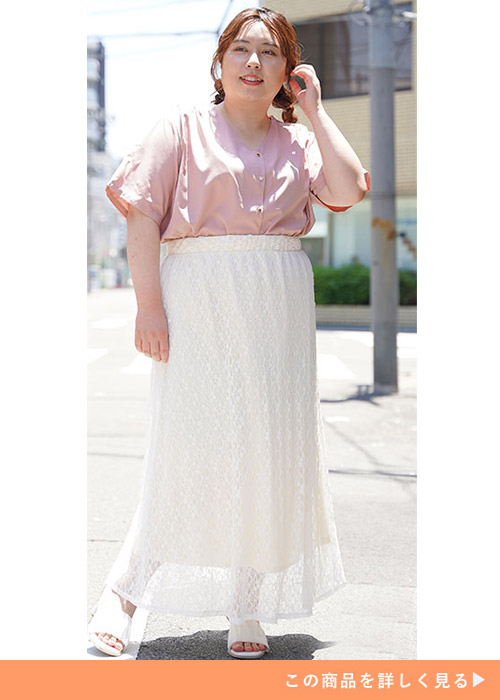 ピンクのシャツブラウスを白のレーススカートにインして着る女性
