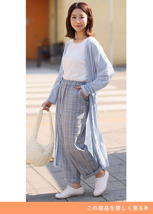 白T×チェック柄パンツに、淡い水色のロングカーディガンを羽織る女性
