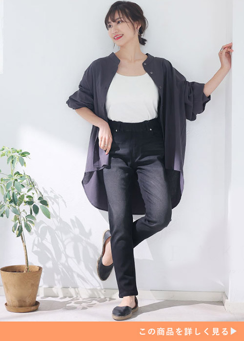 黒スキニーパンツと白Tシャツのコーデにグレーのシャツを羽織る女性