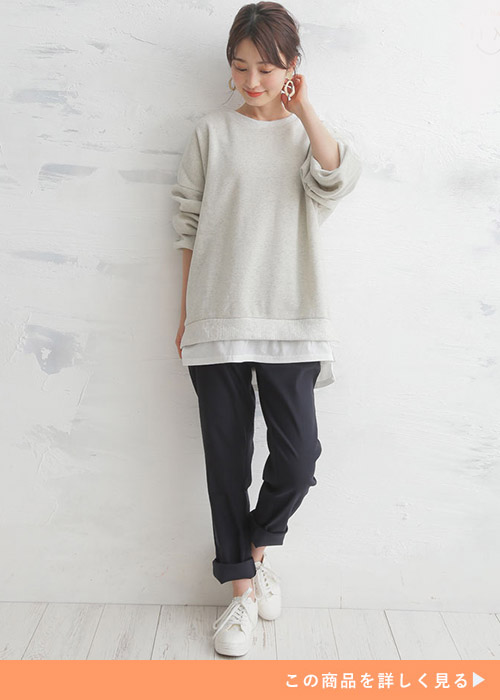 黒のロールアップスキニーパンツとロングスリーブトップスのコーデにスニーカーを履く女性