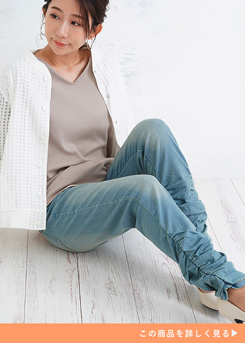 裾がクシュとなったデザインのスキニーパンツとシンプルⅤネックトップスを着る女性