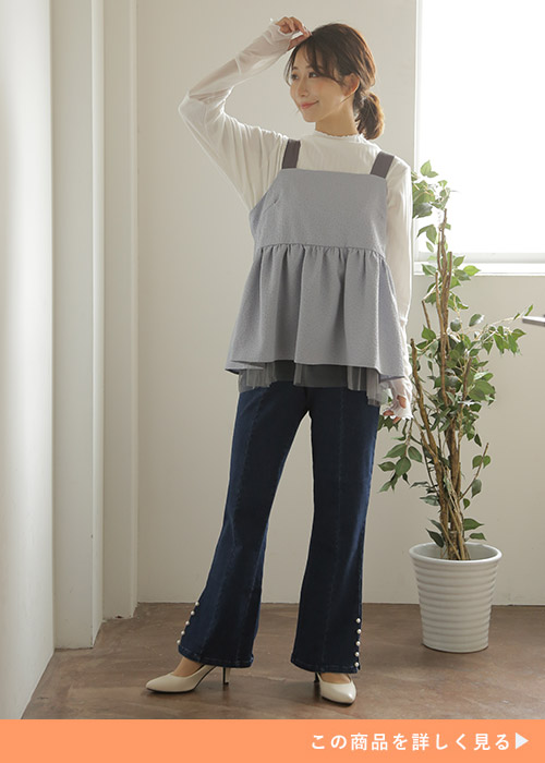 センタープレスフレアスキニーパンツとレイヤードトップスのコーデに白パンプスを履く女性