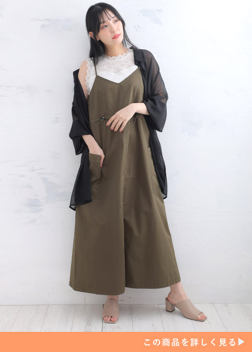 白のレースタンクトップ×カーキのカーゴキャミワンピに黒のシアーシャツを羽織る女性