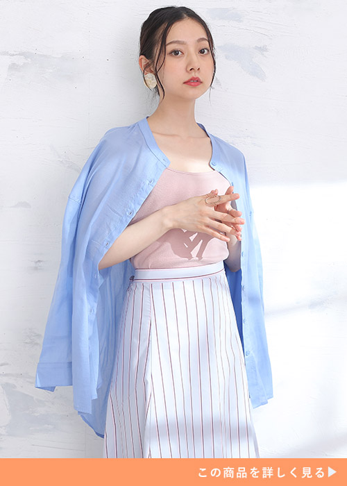 ピンクのトップス×ストライプ柄スカートに、水色のシャツを肩掛けする女性