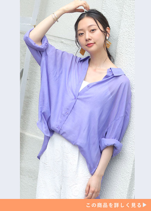 白のワントーンコーデにパープルのシアーシャツを重ねて、袖をロールアップして着る女性