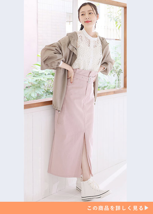 白のレーストップス×ピンクのタイトスカートにベージュのマウンテンパーカを羽織る女性