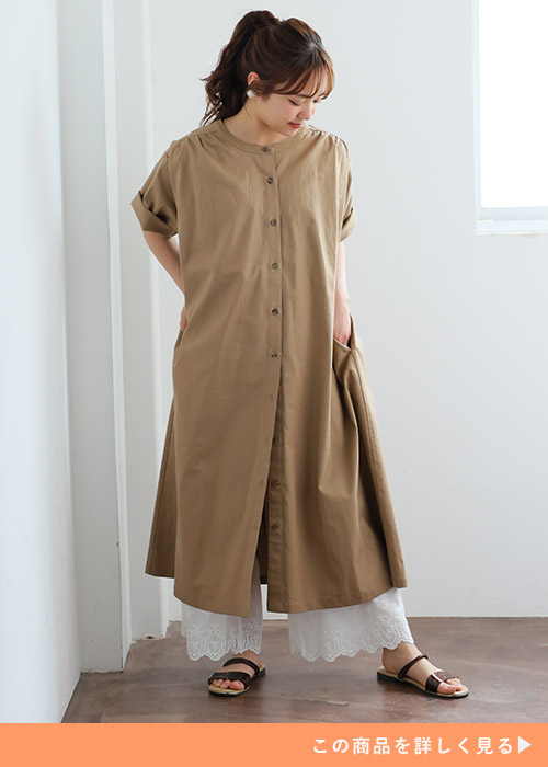 ベージュのシャツワンピースを着て、白の裾レースペチパンツを履く女性