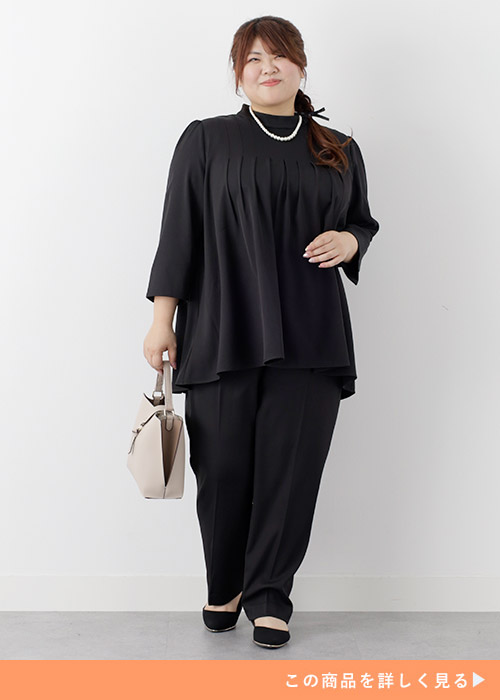 黒のノーカラーセットアップを着る女性