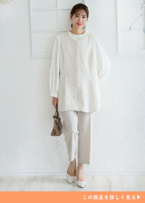 オフホワイトのツイードベストを着る女性