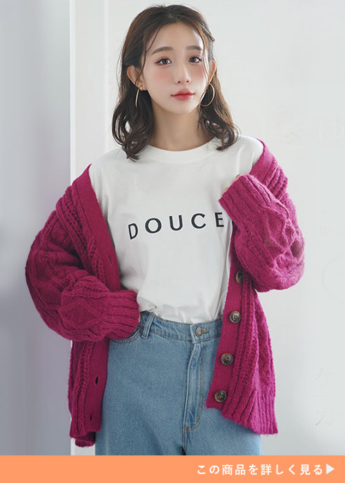 白のロゴT×デニムパンツに、ピンクのカーディガンを羽織る女性