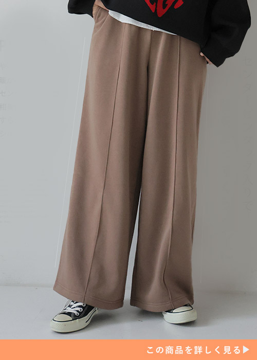 モカブラウン色のセンターシームパンツを履く女性