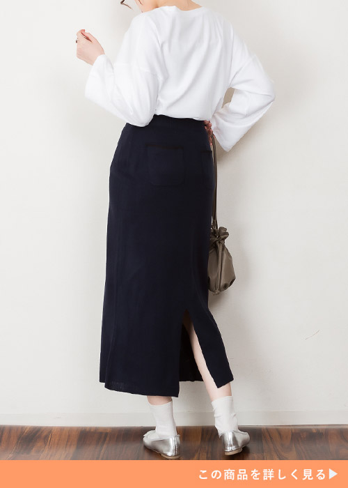 白トップス×黒のバックスリット入りタイトスカートを着る女性