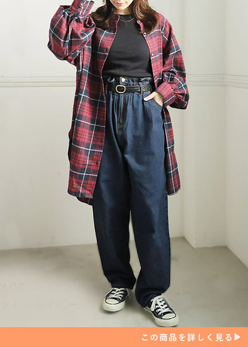 黒トップス×デニムパンツに赤のチェック柄シャツチュニックを羽織る女性