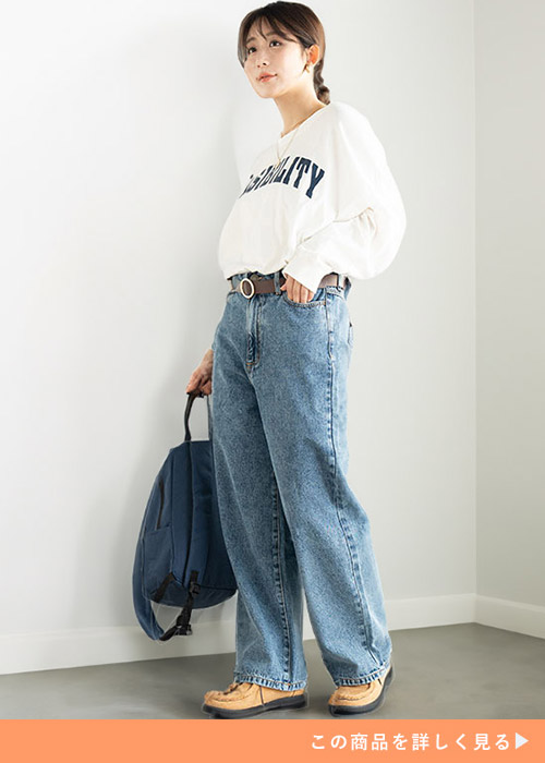 ケミカルネイビーのワイドデニムパンツとホワイトロゴスウェットのコーデにブラウンベルトをする女性
