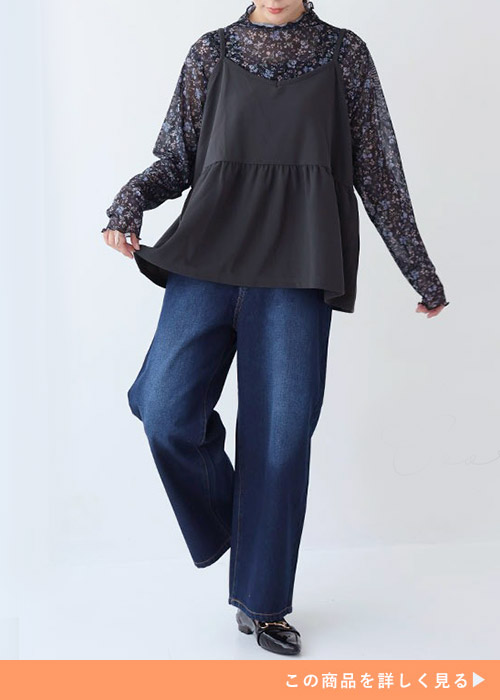 花柄シアートップスとブラックキャミのレイヤードトップスにワイドパンツを履く女性