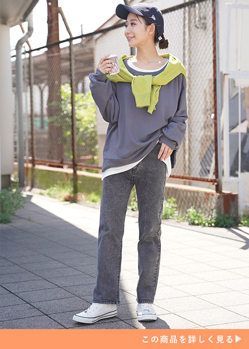 ブラックストレートデニムとロングスリーブレイヤードコーデにイエローのカーデを羽織る女性