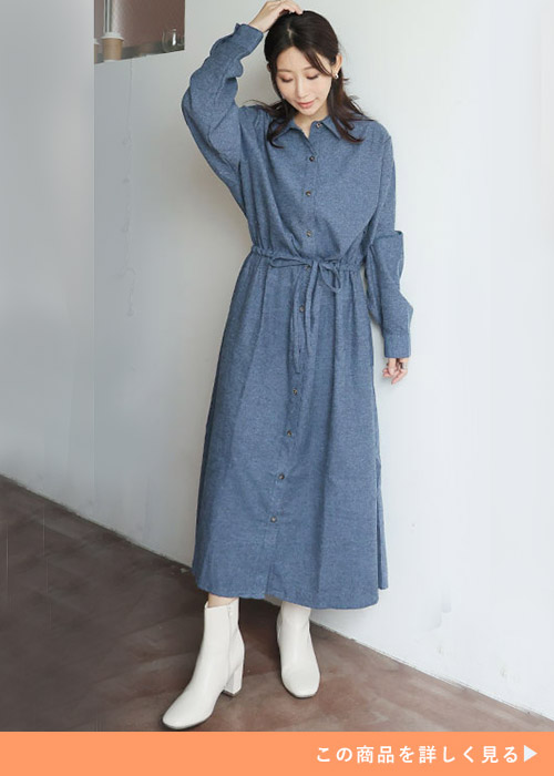 デニムネイビーのロングシャツワンピースにホワイトブーツを履く女性