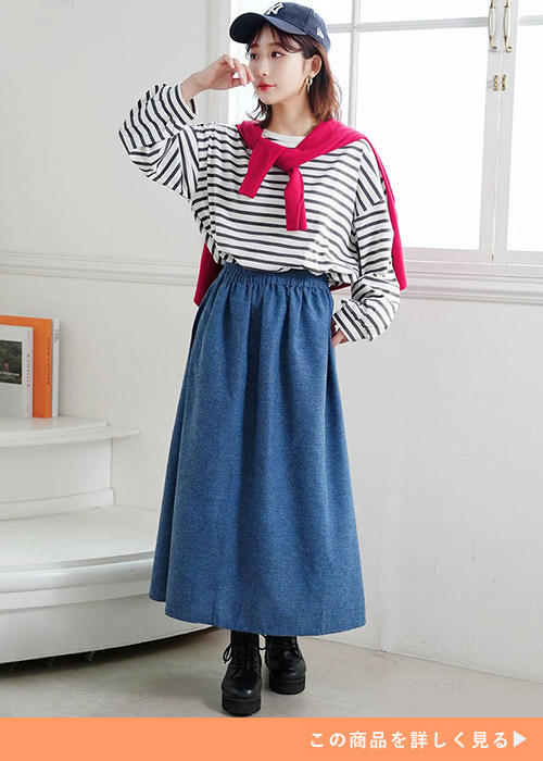 デニムネイビーのフレアスカートにボーダーのトップスとピンクカーデを羽織る女性