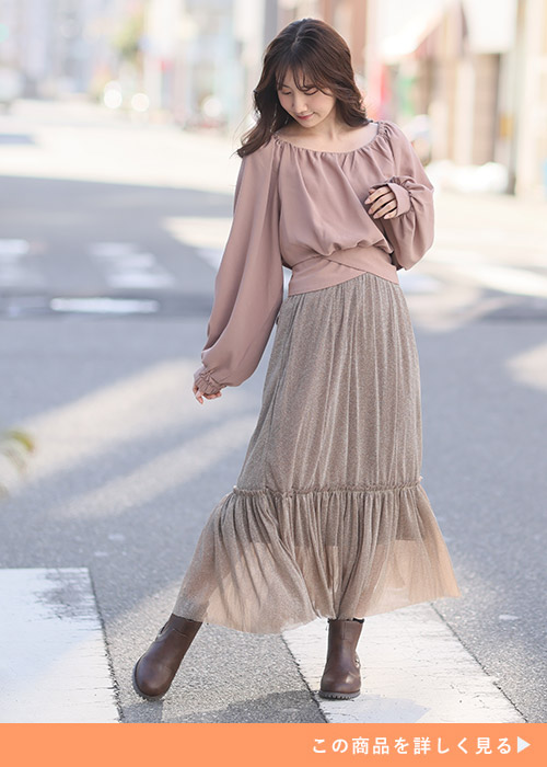 くすみピンクのブラウス×ティアードデザインのチュールスカートのセットアップを着る女性
