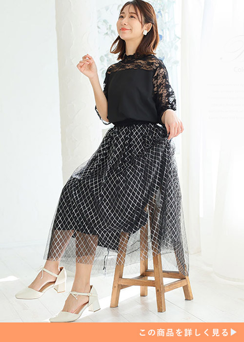 黒のレース切り替えトップス×黒のチェック柄チュールスカートを着る女性