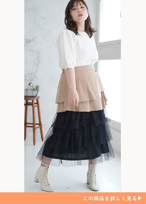 白ブラウスを着てベージュ×ブラックチュールのドッキングスカートを履く女性