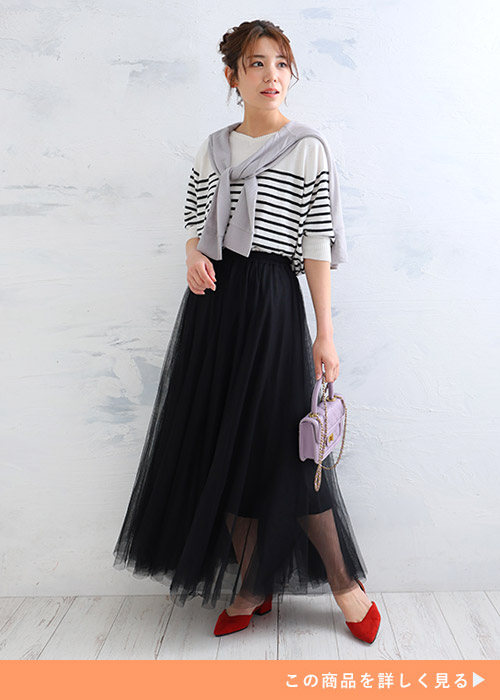 ボーダートップス×黒のロング丈チュールスカートにグレーのトップスを肩掛けする女性