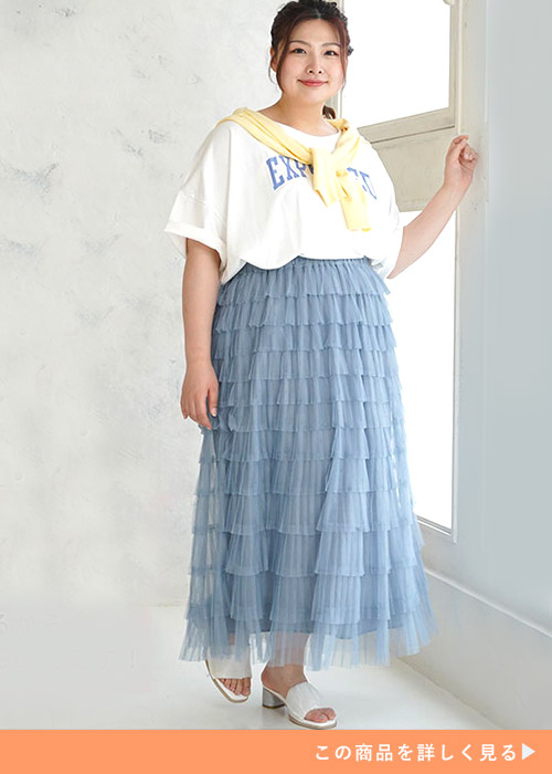 白T×水色のティアードデザインチュールスカートを着て、黄色のトップスを肩掛けする女性