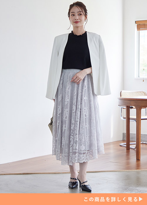 黒トップス×グレーのレーススカートに、ジャケットを肩掛けする女性