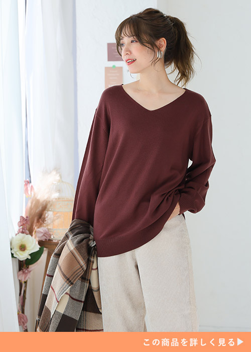 ブラウンのVネックニット×アイボリーのパンツを着る女性